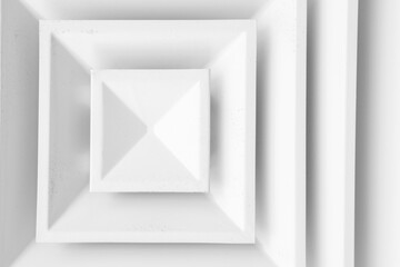 White ceiling ventilation grille with square diffusors, close-up
