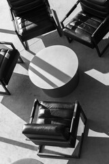 Black armchairs stand around white round table at meeting room