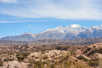 A sunny morning scene in a mountain Andean landscape in Mendoza, Argentina. Snowy peaks stand out on the horizon.