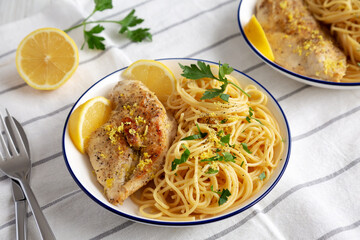 Homemade Lemon Pepper Chicken with Spaghetti Pasta on a Plate, side view.