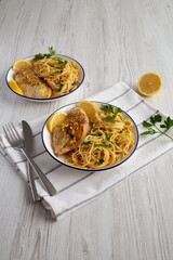 Homemade Lemon Pepper Chicken with Spaghetti Pasta on a Plate, side view.