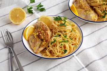 Homemade Lemon Pepper Chicken with Spaghetti Pasta on a Plate, side view.