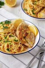 Homemade Lemon Pepper Chicken with Spaghetti Pasta on a Plate, side view.