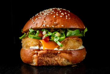 Close-up of a burger with sesame seed bun, cheese, greens, and sauce on a dark background