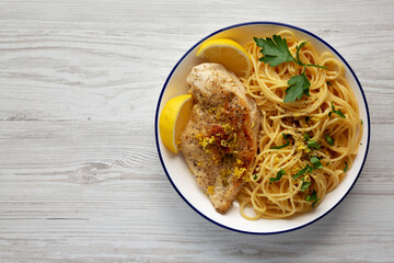 Homemade Lemon Pepper Chicken with Spaghetti Pasta on a Plate, top view. Copy space.
