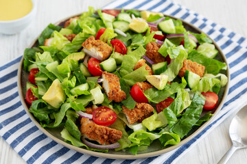 Homemade Crispy Chicken Salad with Tomato and Cucumber on a Plate, side view.