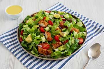 Homemade Crispy Chicken Salad with Tomato and Cucumber on a Plate, side view.