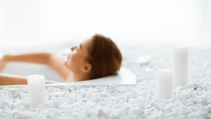 Total relaxation. Woman enjoying hot bath with candles, relaxing after hard day, free space