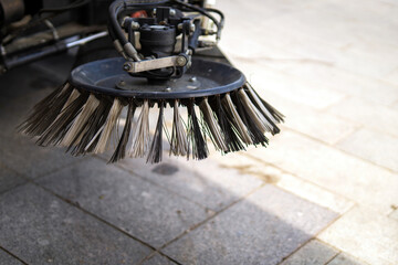 Circular synthetic-bristle broom on a street sweeper, highlighting urban cleanliness and...