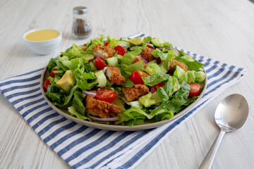 Homemade Crispy Chicken Salad with Tomato and Cucumber on a Plate, side view. Close-up.