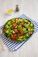 Homemade Crispy Chicken Salad with Tomato and Cucumber on a Plate, side view. Close-up.