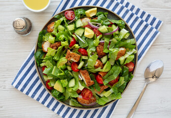 Homemade Crispy Chicken Salad with Tomato and Cucumber on a Plate, top view.