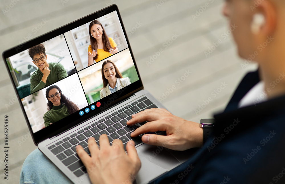 Poster a man is sitting in a chair, using a laptop computer to participate in a video conference call. he i