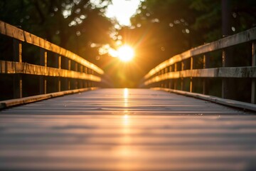 A serene sunset view from a wooden bridge, capturing the warm glow of the sun setting through lush green trees.