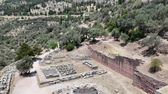 Aerial bird's eye view video taken by drone of archaeological site of ancient Delphi, site of temple of Apollo and the Oracle, Voiotia, Greece