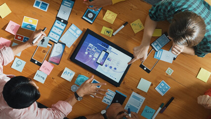 Top view of software developer team looking Ux Ui design for mobile phone interface from tablet...