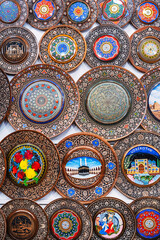 handmade Uzbek wooden gift plates with wood carvings hand-painted asian patterns in the souvenir market of Uzbekistan