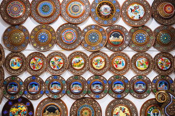 handmade Uzbek wooden gift plates with wood carvings hand-painted oriental patterns in the souvenir shop of Uzbekistan