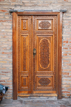 modern carved wooden doors with tajik carved pattern with Islamic ornament in oriental kandakori style in Tadjikistan