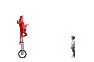 Little boy watching an acrobat on a giraffe unicycle