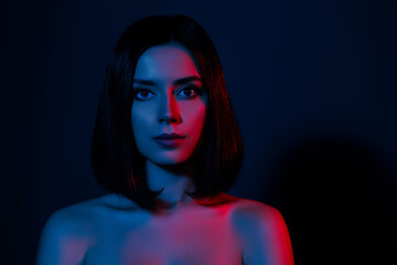 Portrait of brunette hair lady look in camera isolated dark color neon background