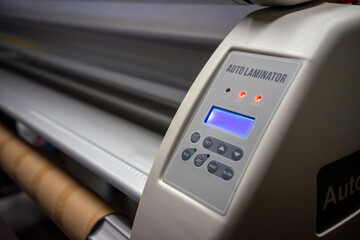 A machine for lamination with vinyl film.Cutting plotter in production.
