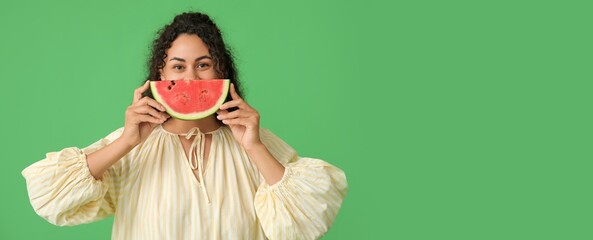 Happy young African-American woman with slice of fresh watermelon on green background with space for text