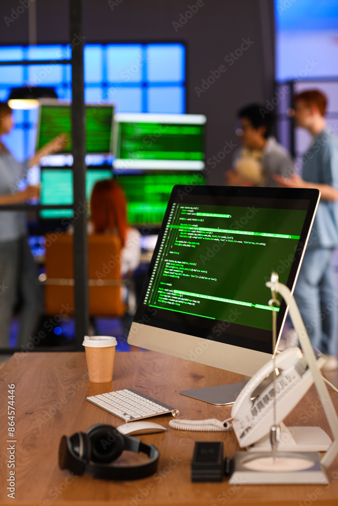 Poster programmer's workplace with computer and cup of coffee in office at night