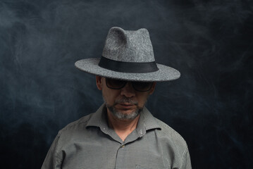 Portrait of man with beard and sunglasses and hat posing for photography.