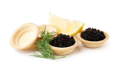 Tasty tartlets with black caviar and lemon on white background