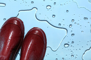 Red gumboots in water on blue background