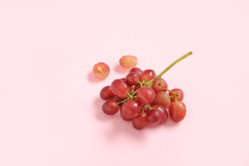 Tasty ripe grapes on pink background