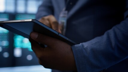 Software developer doing yearly maintenance using tablet to prolong data center equipment life...
