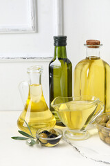 Different glassware of fresh olive oil on table