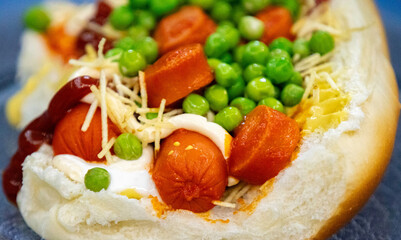 Traditional Brazilian style hot dog with sausage, peas and straw potatoes