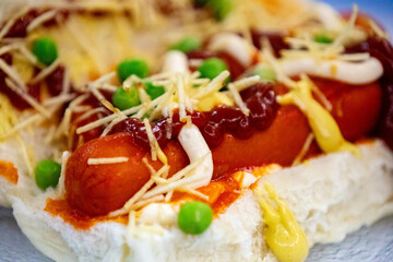Traditional Brazilian style hot dog with sausage, peas and straw potatoes