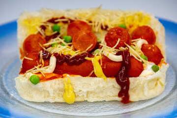 Traditional Brazilian style hot dog with sausage, peas and straw potatoes