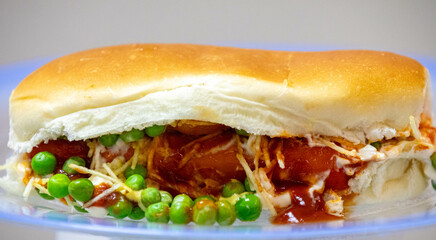 Traditional Brazilian style hot dog with sausage, peas and straw potatoes