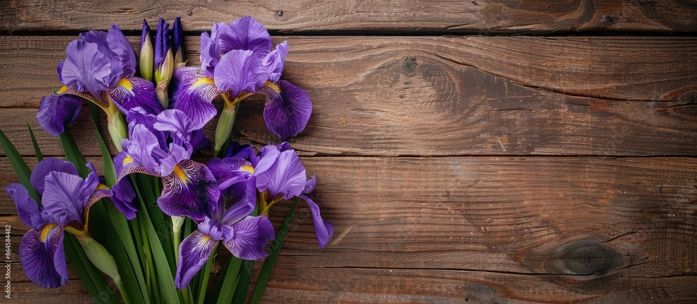 Poster top view of purple iris flowers arranged on a wooden surface with a clear area suitable for adding t