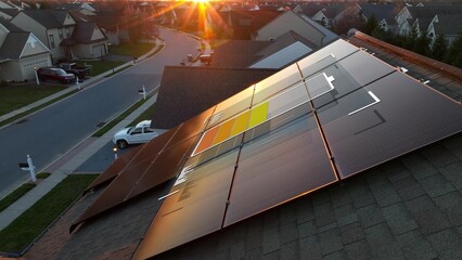3D Battery over solar panel array on rooftop of American home during sunset. Graphic