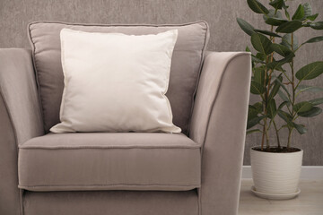 Soft pillows on grey armchair in room