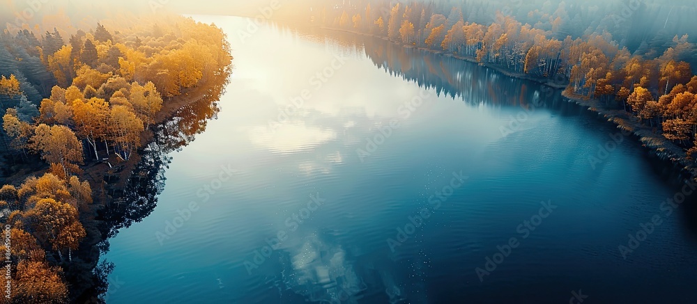 Poster a serene aerial photograph capturing the autumn sun reflecting on a vast lake with ample space for t