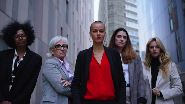 Portrait of multiracial and diverse ages business women in formal suits posing serious with arms crossed looking at camera. Empowered and successful female entrepreneurs happy and powerful outdoor