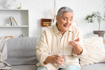 Senior woman taking pills at home