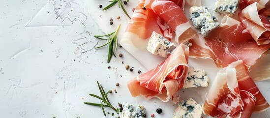 Copy space image of Prosciutto or Spanish jamon paired with blue cheese and rosemary, representing traditional Mediterranean snacks.