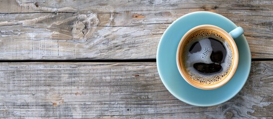 Bird's-eye view of a coffee cup on a textured wooden table, featuring a pleasing copy space image.