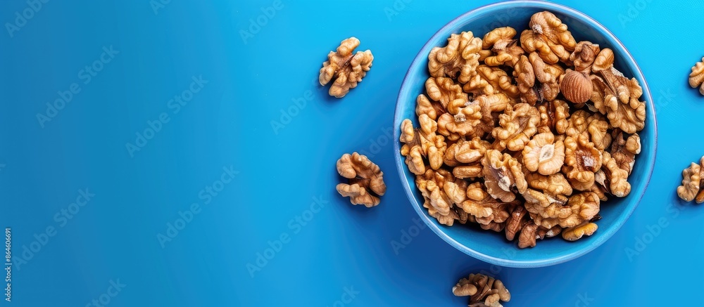 Poster high angle view of a walnut snack on a blue backdrop with copy space image.