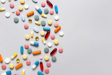 Frame made of different colorful pills on grey background