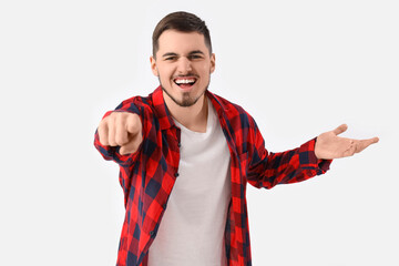 Angry young man pointing at viewer on white background. Accusation concept