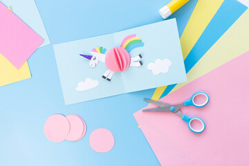 Three-dimensional paper craft with a colorful paper, Scissors and glue in the scene indicate the craft's creation, highlighting creativity and craftsmanship.,